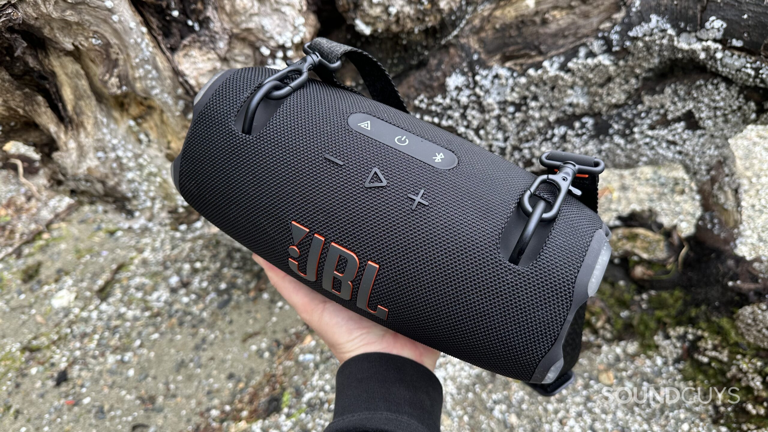 JBL Xtreme 4 hand 2 A hand holding the JBL Xtreme 4 speaker on a slight angle at the beach.