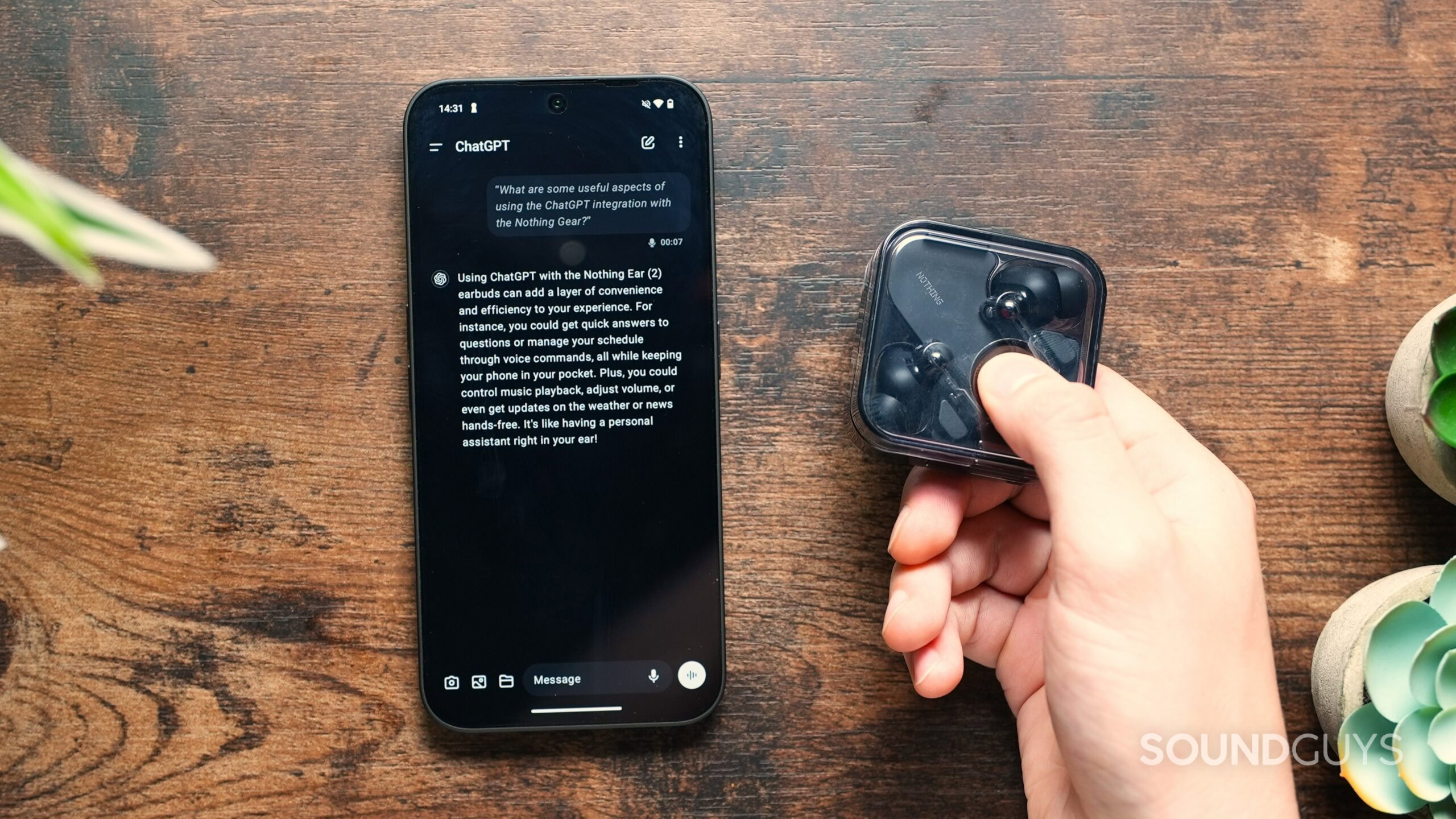 a hand holding the Nothing Ear case beside a phone with ChatGPT on screen a hand holding the Nothing Ear case beside a phone with ChatGPT on screen