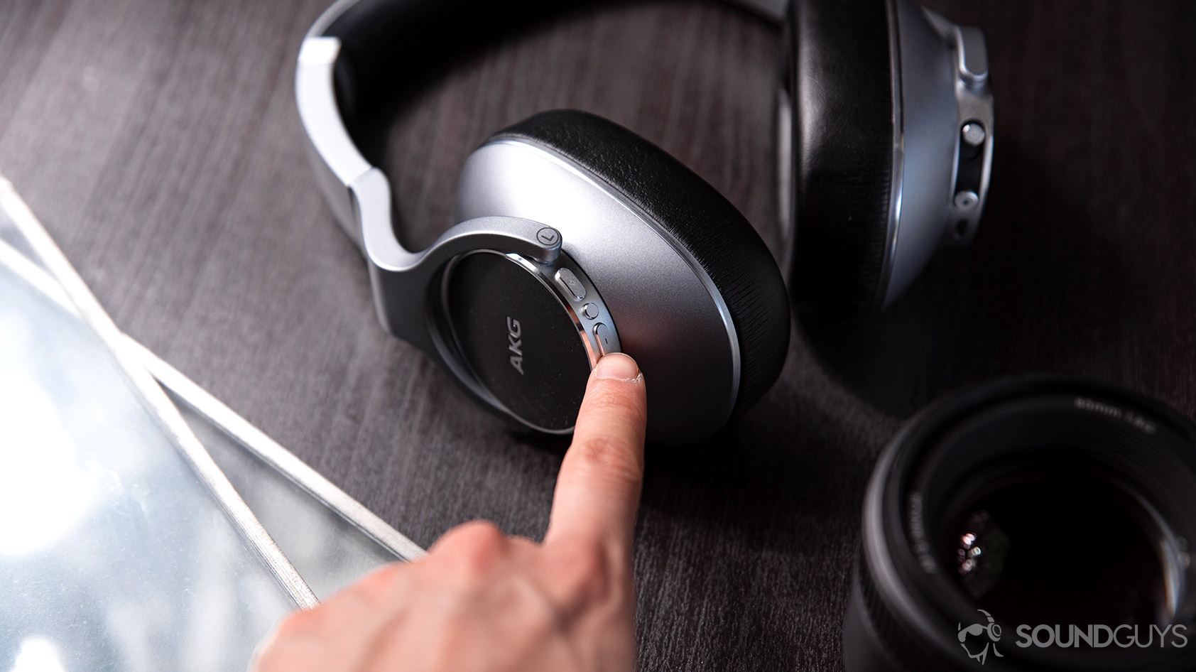 AKG_N700NC-4_hand reach button control AKG N700NC: A hand reaching out for the volume controls on the left ear cup.