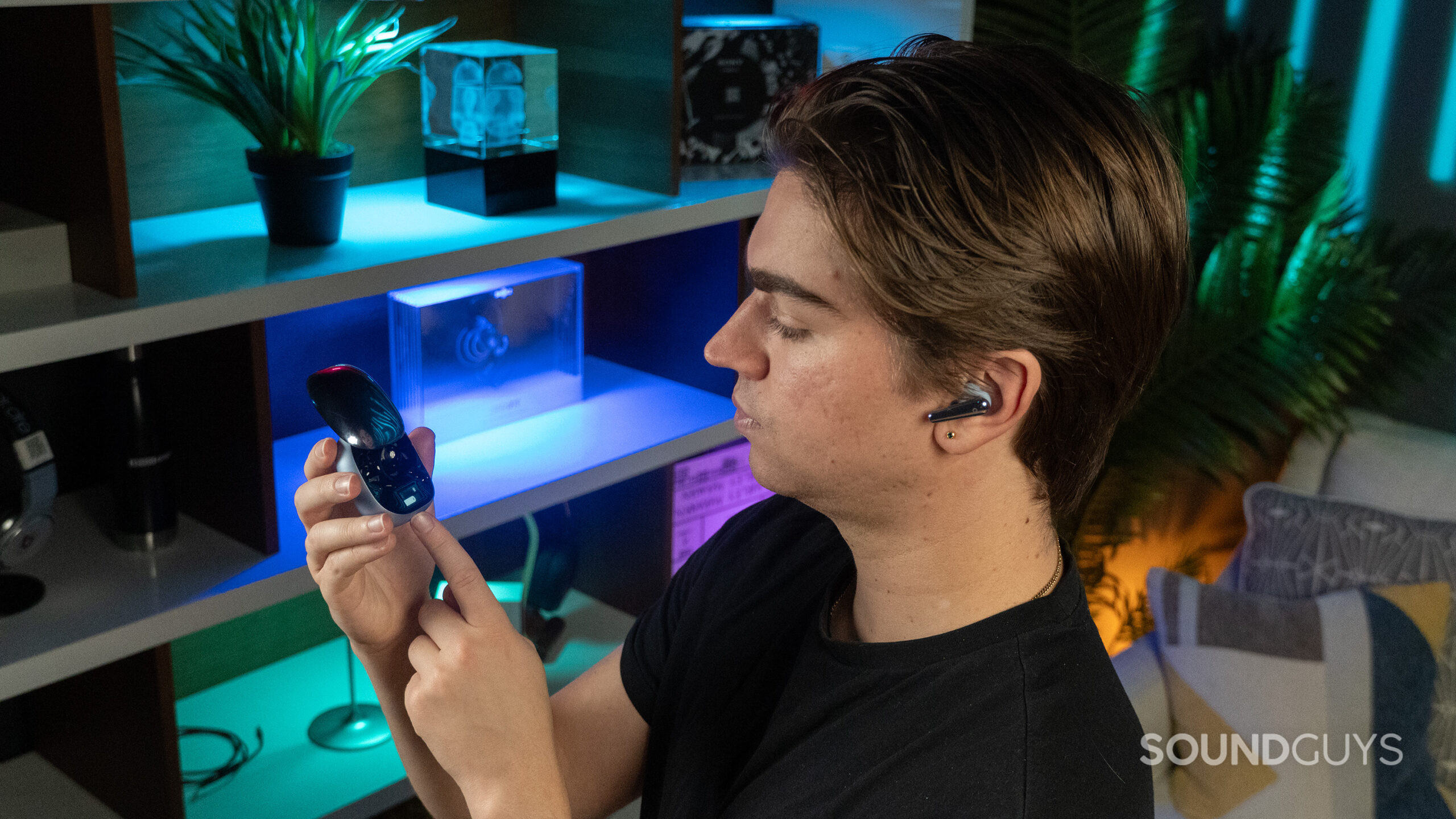 Anker Soundcore Liberty 4 Pro hand touching panel A man wearing the Anker Soundcore Liberty 4 Pro, using the touchbar on the charging case.