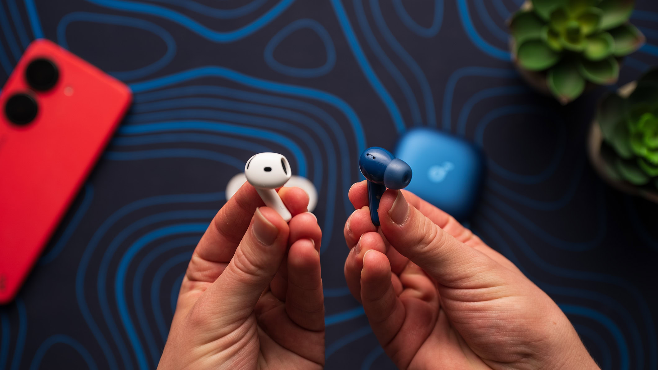 Anker Soundcore Liberty 5 earbud next to an Apple AirPods 4 earbud.