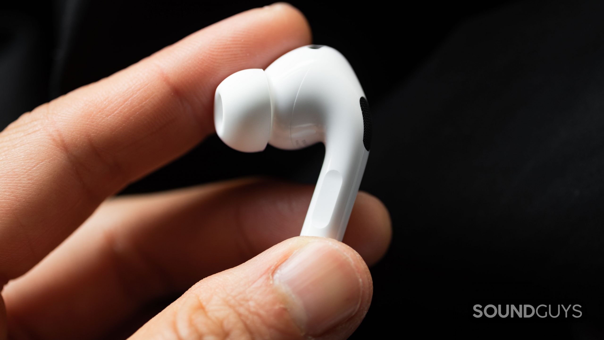 Apple AirPods Pro (2nd generation) true wireless earbuds stem control hand 2 A hand holds the left earbud of the Apple AirPods Pro (2nd generation) to show off the stem.