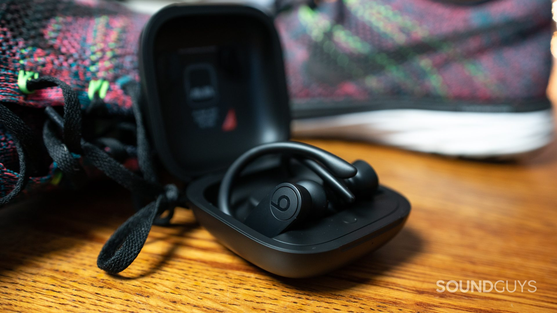 Apple Airpods Vs Powerbeats Pro-5 The Beats Powerbeats Pro next to running sneakers.