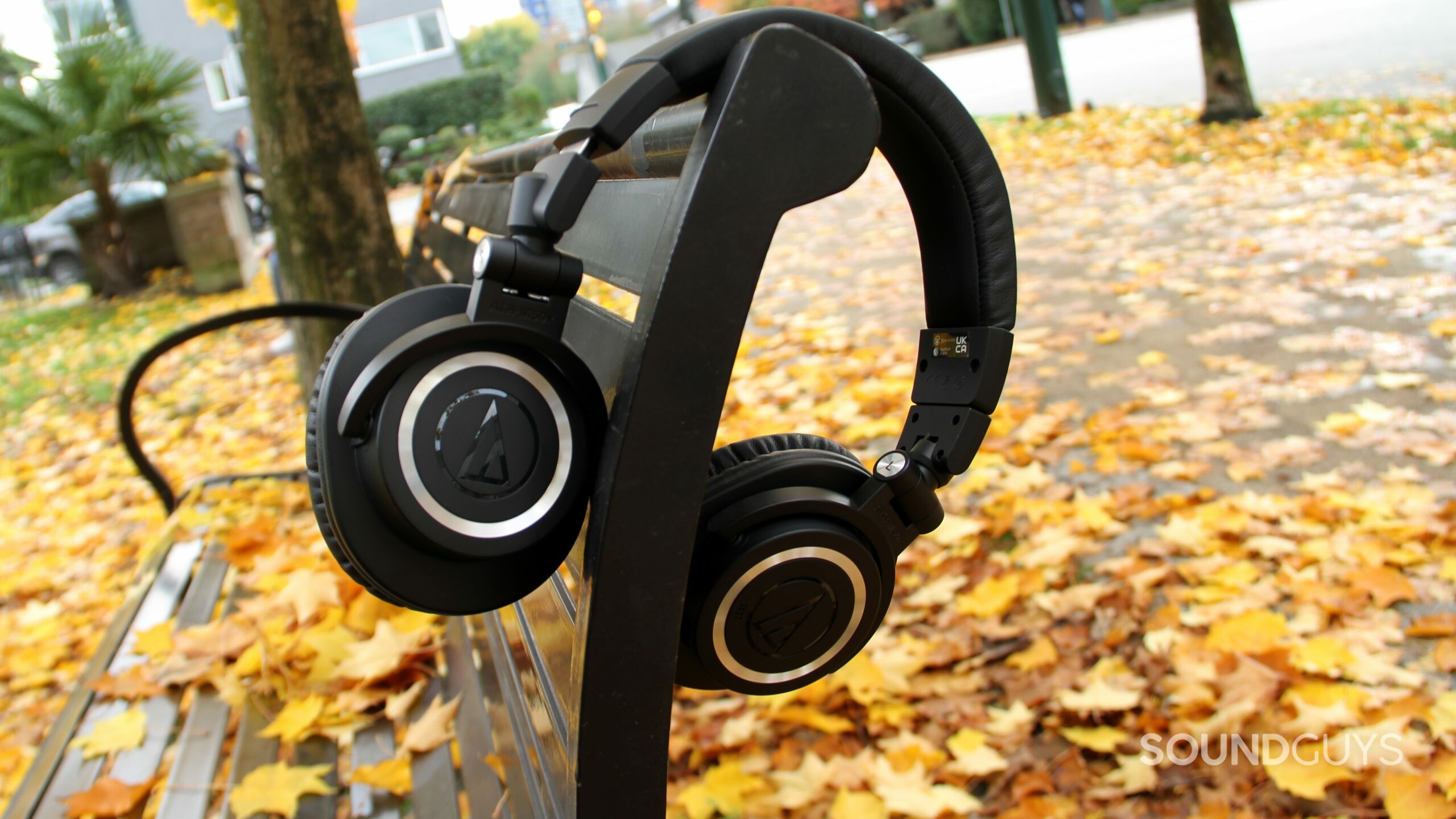 audio-technica-ath-m50xbt2-bench Audio-Technica ATH-M50xBT2 slung over the back rest of a bench.