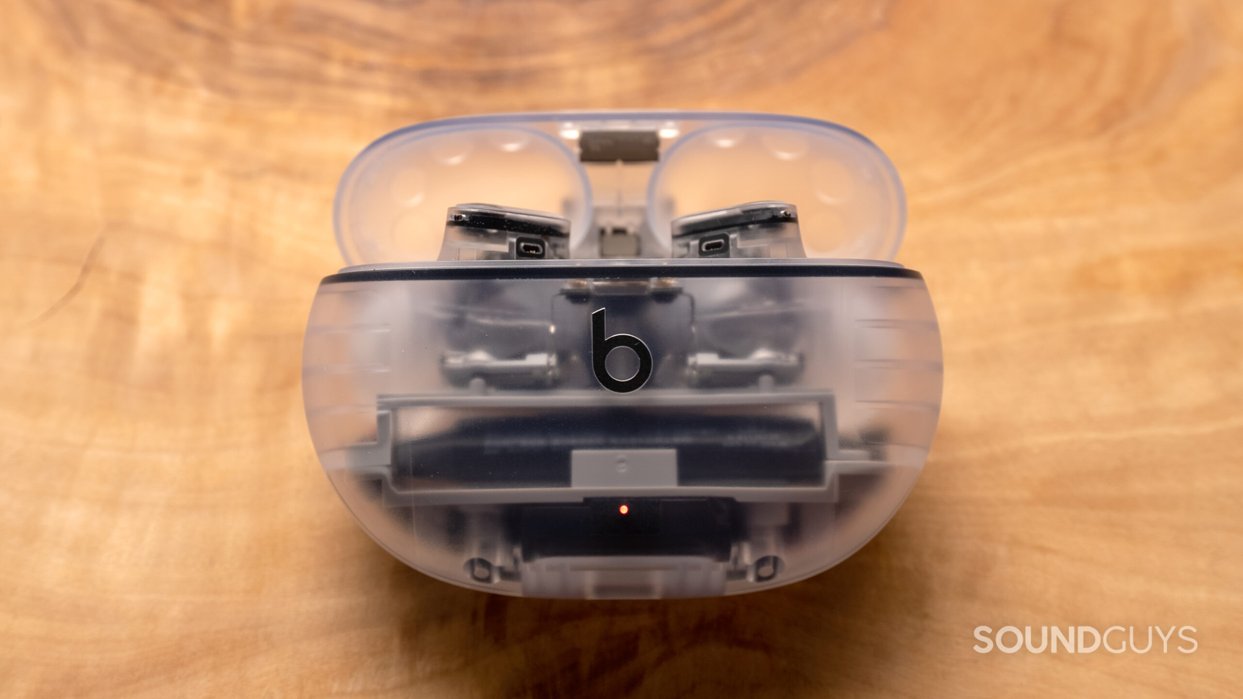 beats-studio-buds-case Image of a Beats Studio Buds Plus transparent case resting on a wooden surface