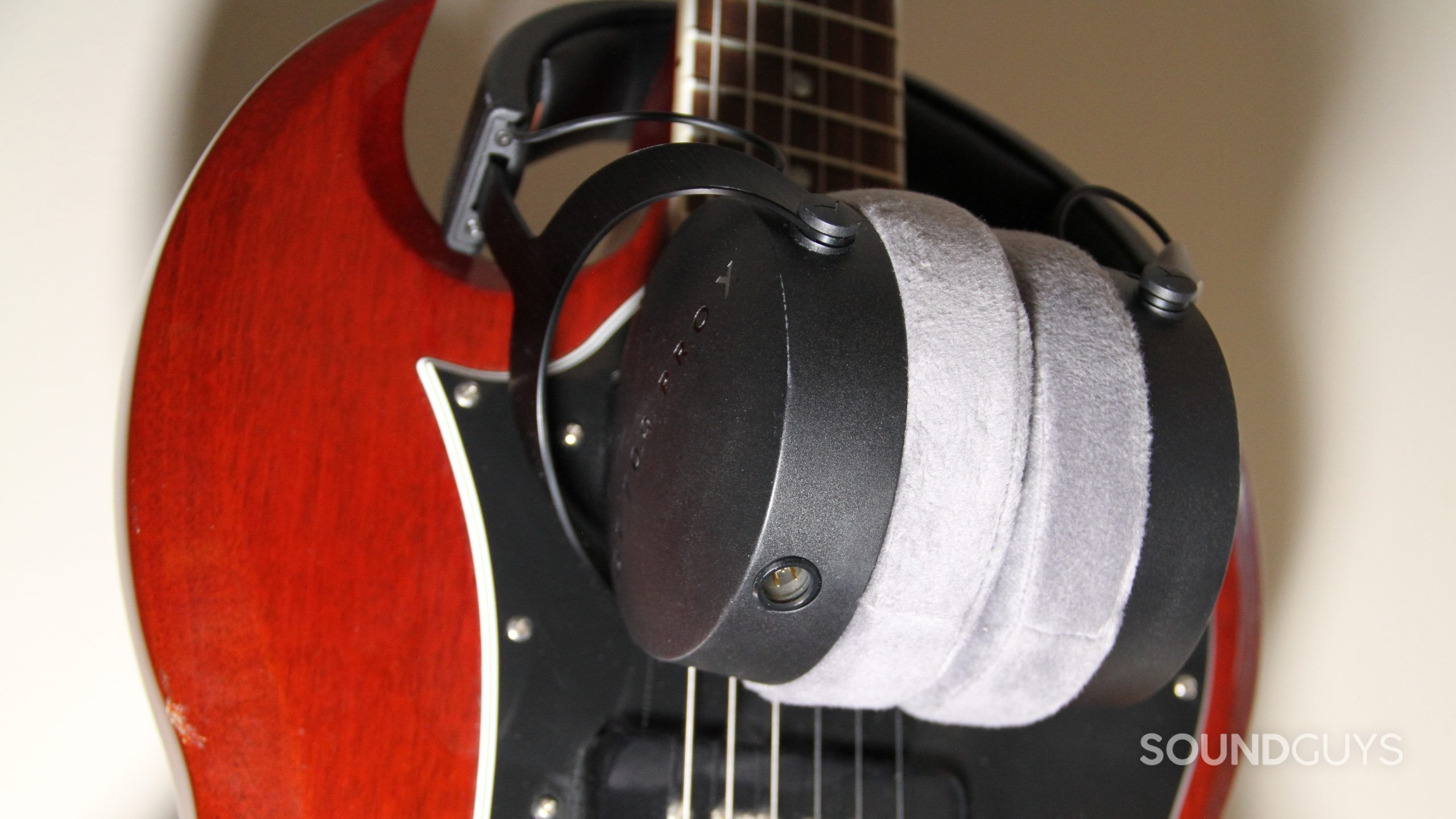 beyerdynamic-dt-700-pro-x-xlr-connector-and-padding The Beyerdynamic DT 700 Pro X sits around the neck of a red guitar showing the cable connector.