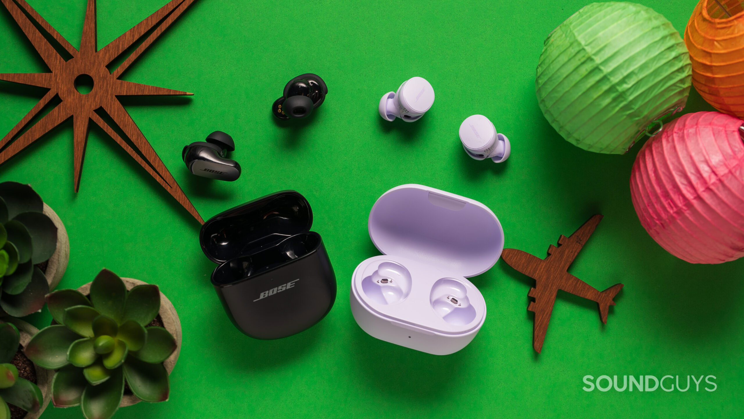 Bose QuietComfort Earbuds vs Bose QuietComfort Ultra Earbuds next to case Bose QuietComfort Earbuds next to Bose QuietComfort Ultra Earbuds on a table with the earbuds next to the case.