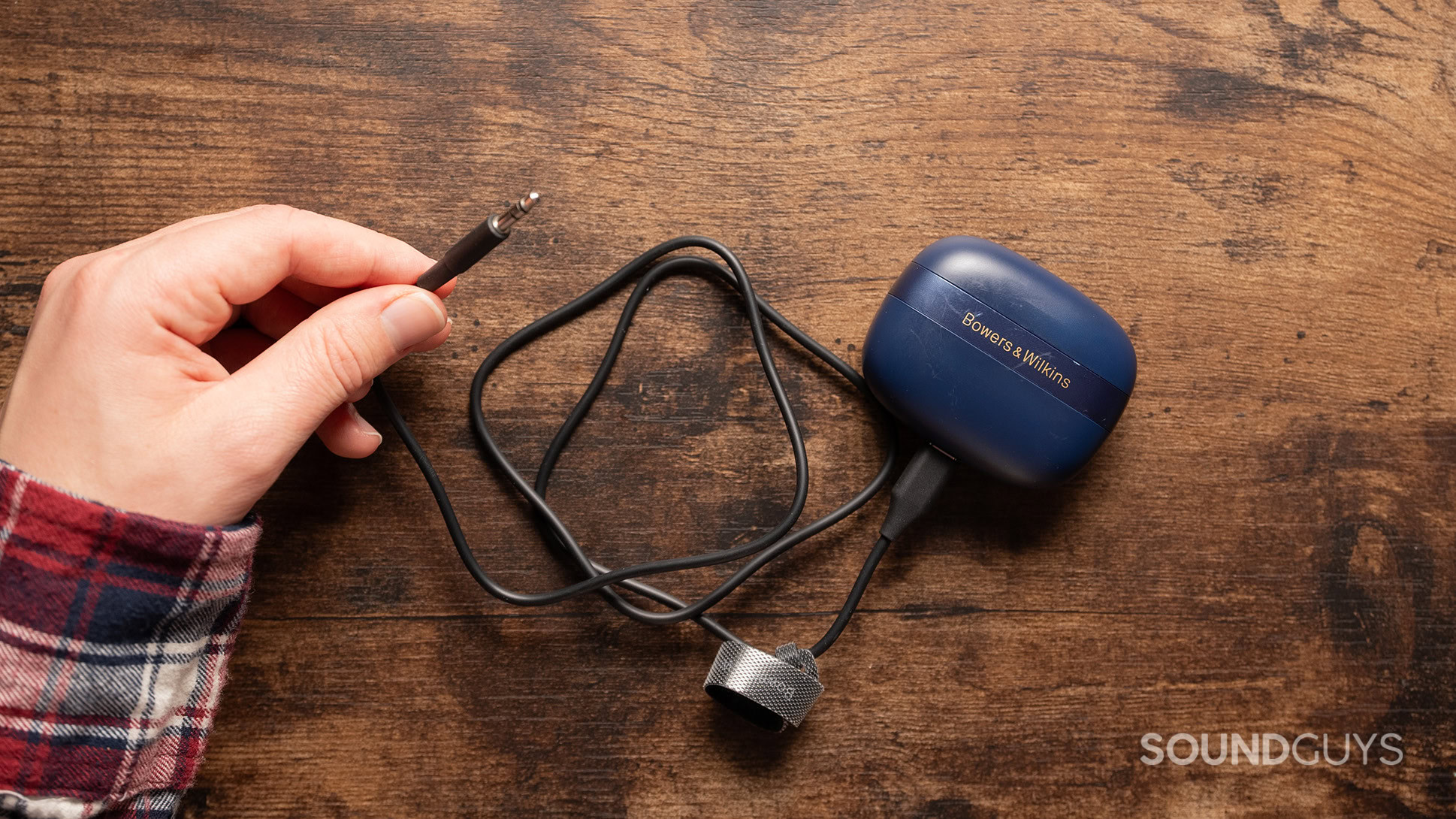Bowers & Wilkins Pi8 transmitter cable A hand holding the 3.5mm transmitter cable for the Bowers & Wilkins Pi8.