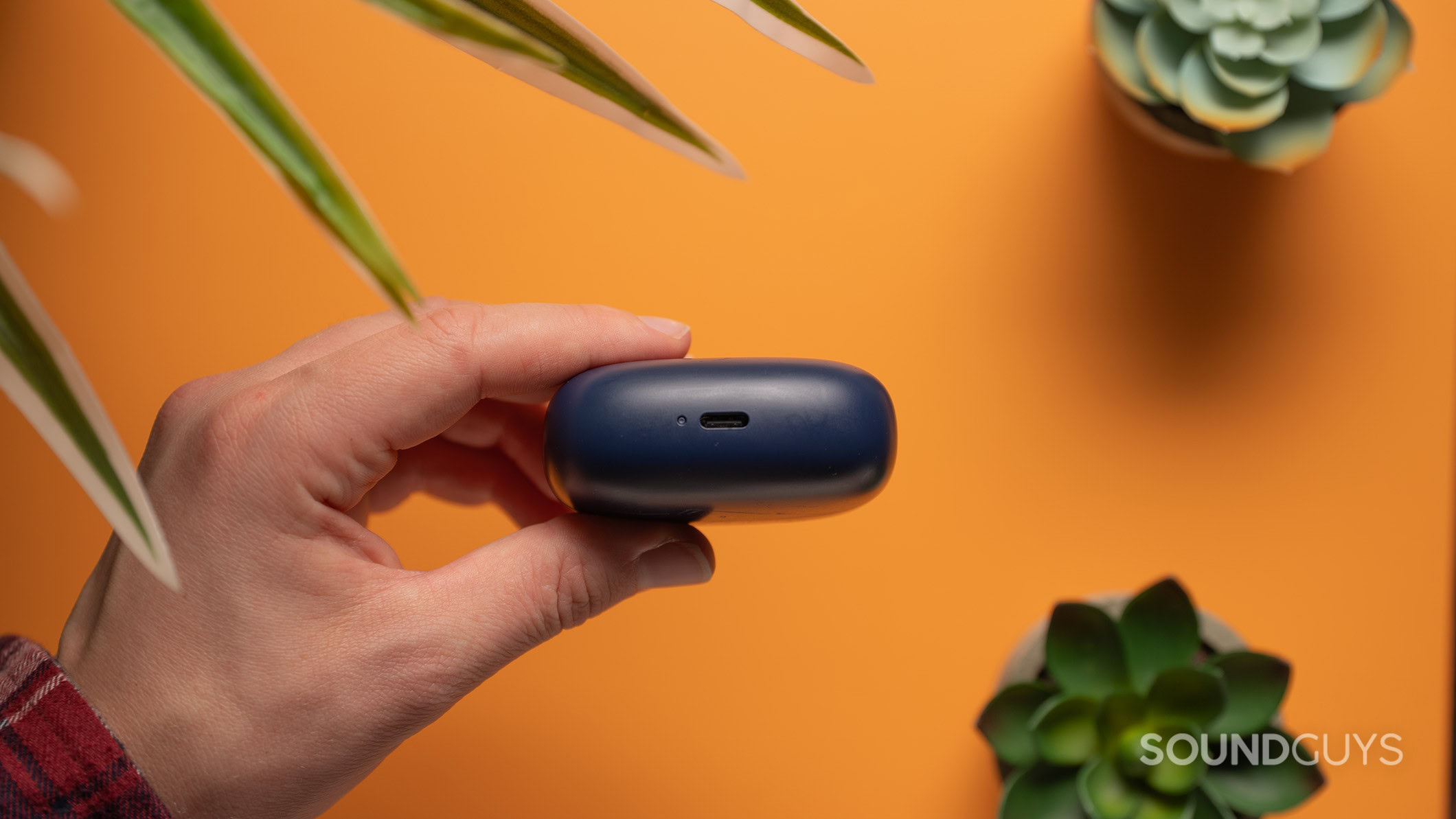 Bowers & Wilkins Pi8 usb c charging port A hand holds the Bowers & Wilkins Pi8 charging case showing the USB-C port.