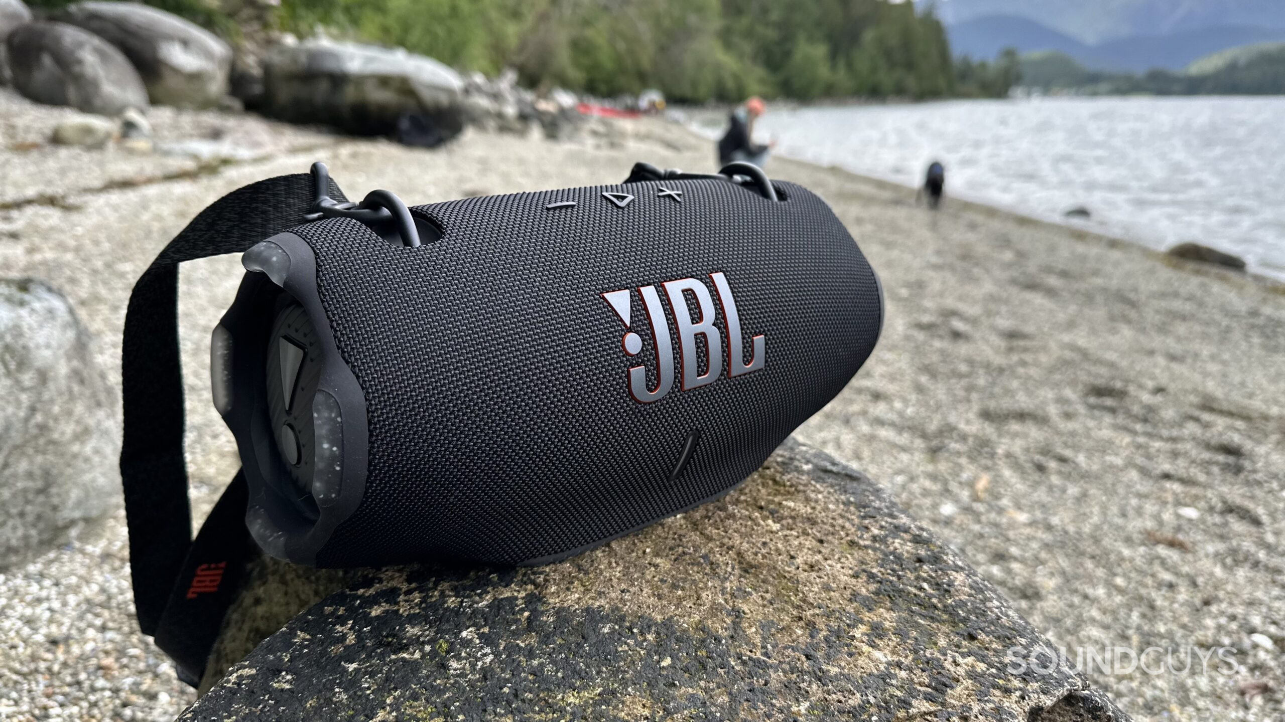 JBL Xtreme 4 rock 3 A JBL Xtreme 4 placed on a rock at the beach.