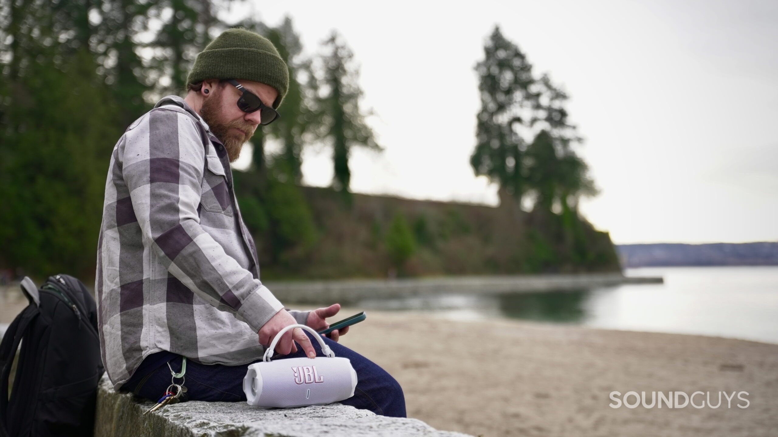 Charge 6 - 16 A man using the JBL Charge 6 speaker at the beach.