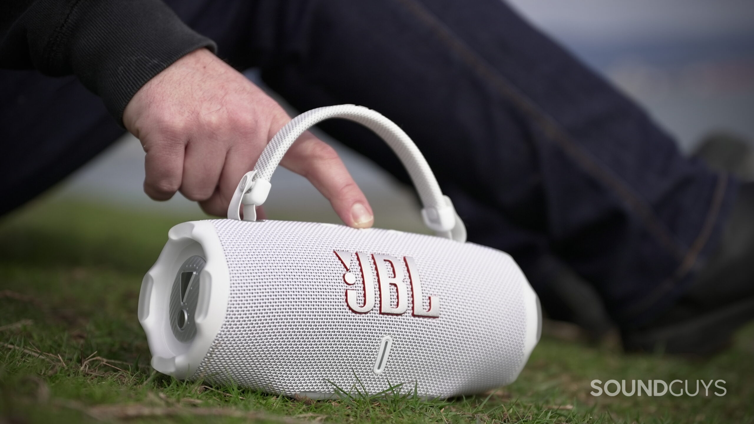 Charge 6 - 6 A man using the controls on a JBL Charge 6 speaker.