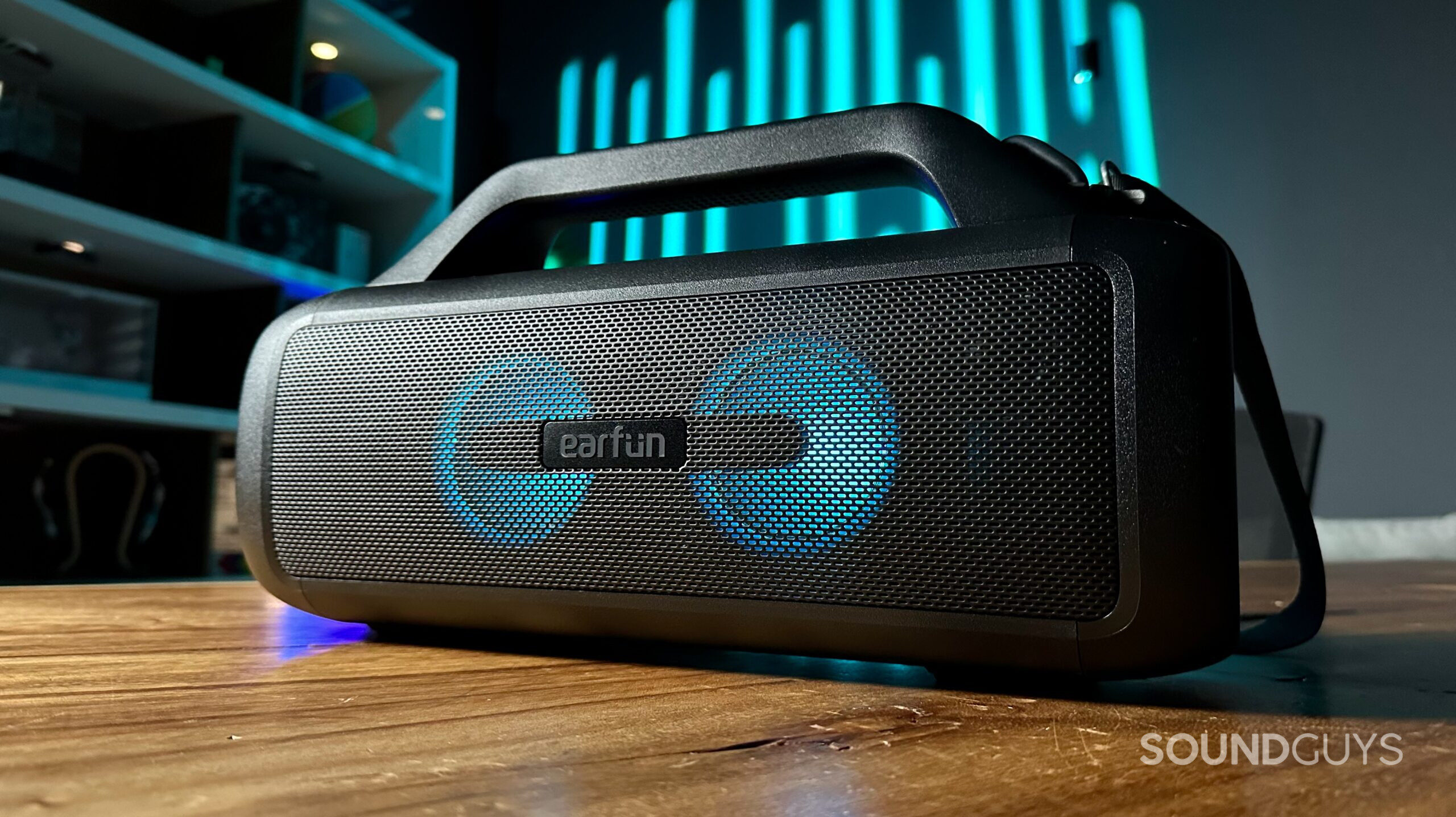 EarFun UBOOM X_1 An EarFun UBOOM X speaker on a wooden table in a nicely lit room.