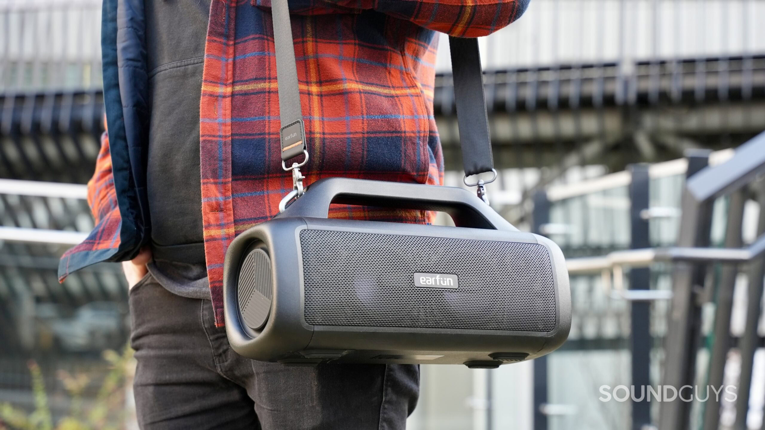 EarFun UBOOM X_19. A man carrying the EarFun UBOOM X by its shoulder strap.