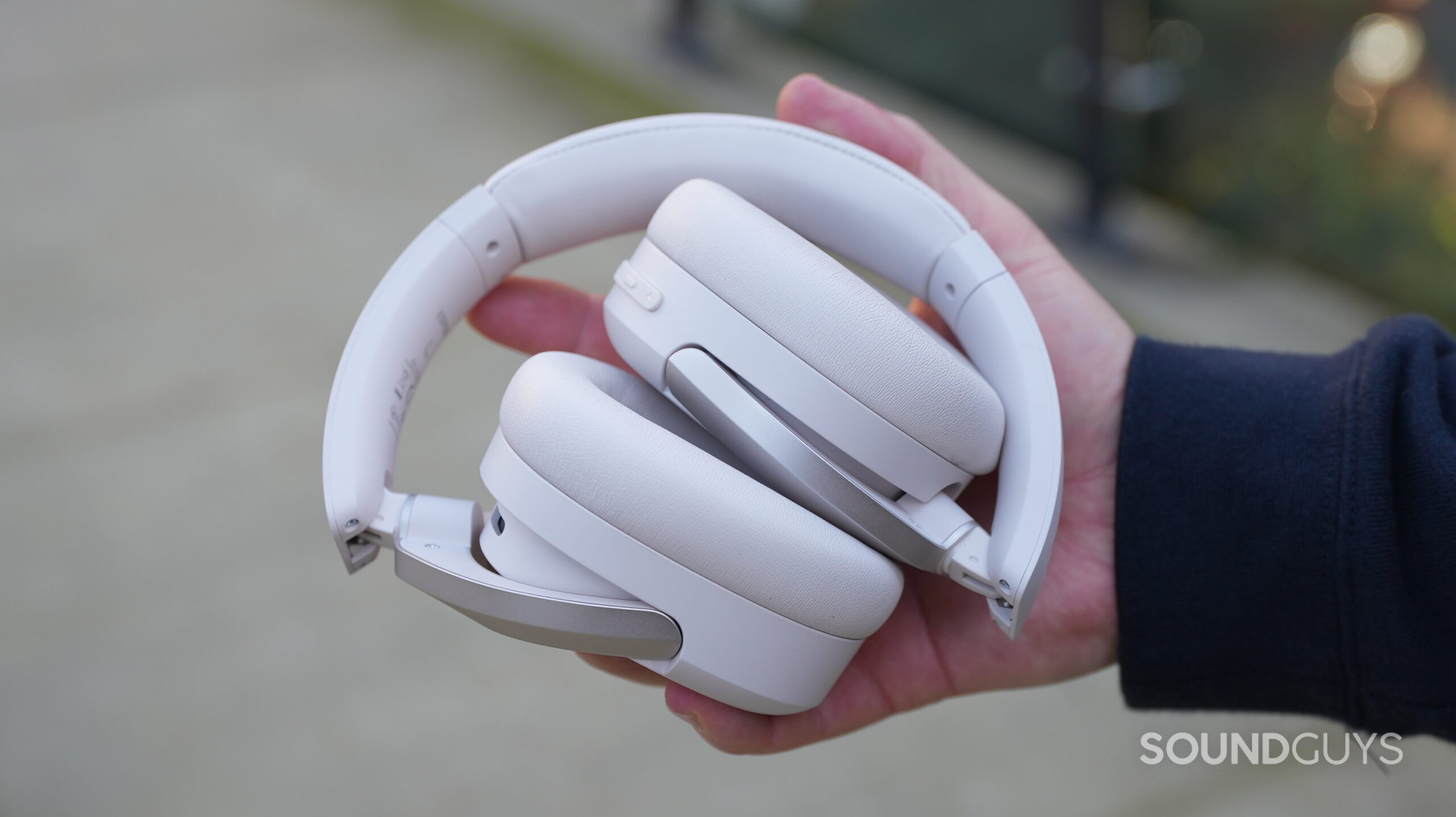 Edifier W830NB_6 A hand holds a folder up pair of Edifier W830NB headphones.