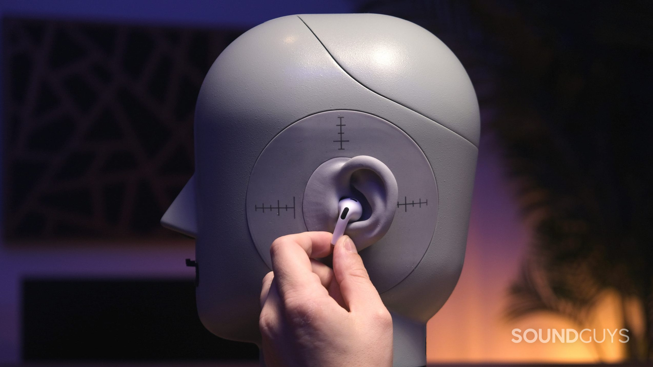 Hedy with the AirPods 3rd Gen A hand holds one of the Apple AirPods (3rd generation) to the ear of a head simulator.