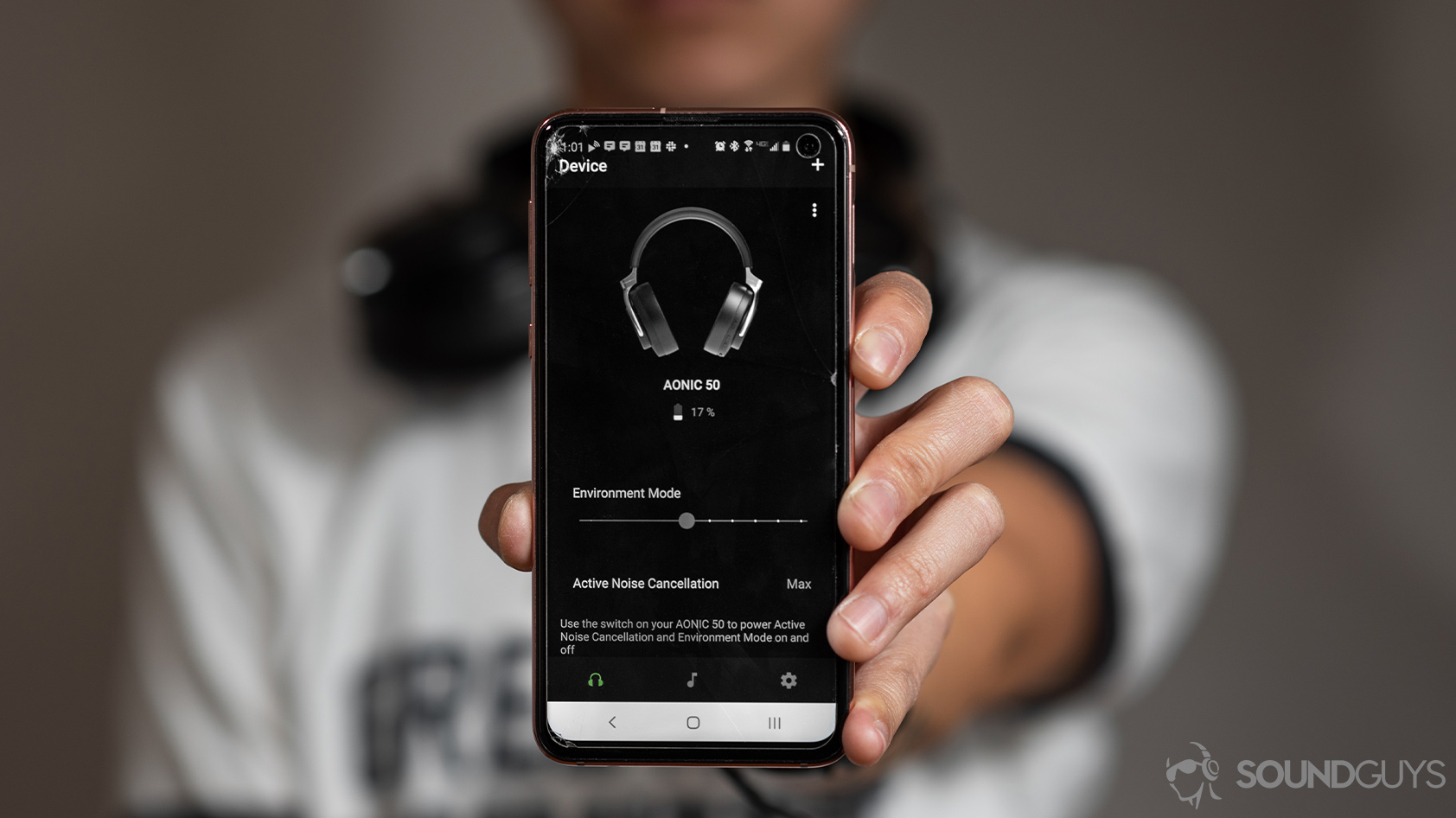 headphone data collection-Shure AONIC 50 PlayPlus app 2 A woman using the Shure PlayPlus headphone app centered in the frame with the Shure AONIC 50 noise canceling headphones on the display.
