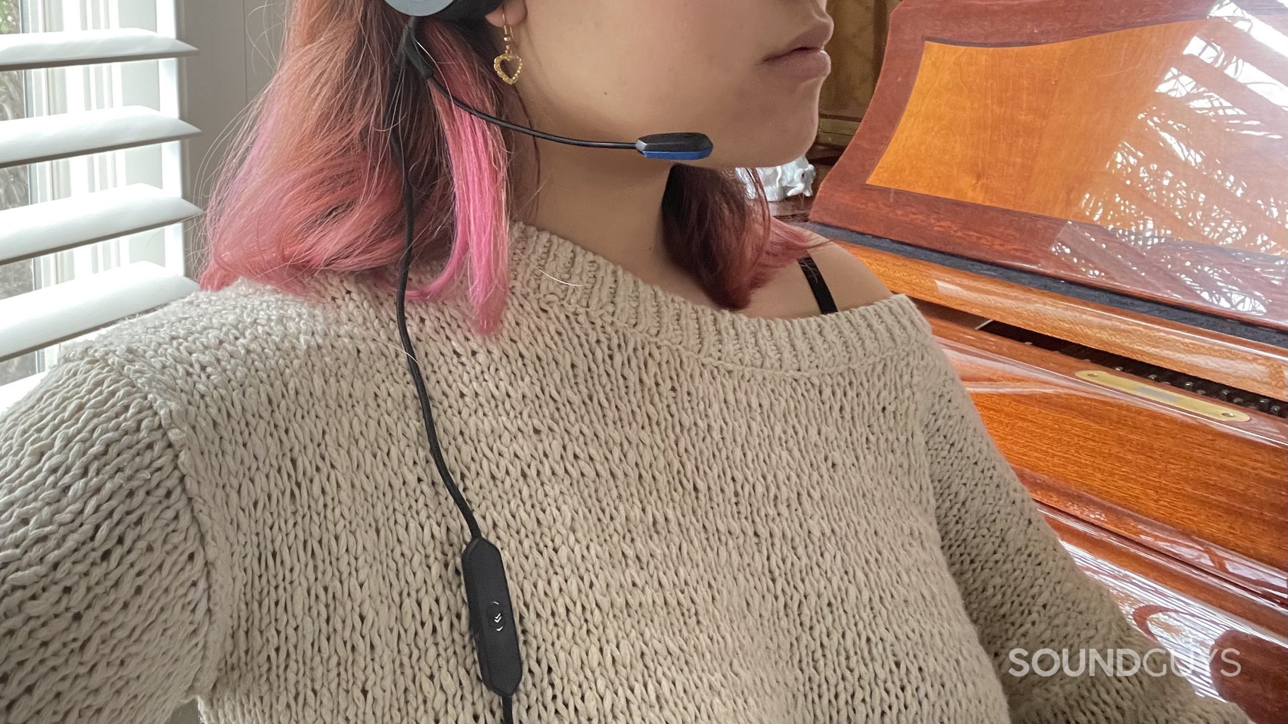 V-Moda BoomPro X mic control woman wears Woman wearing the V-MODA BoomPro X plugged into a pair of headphones.