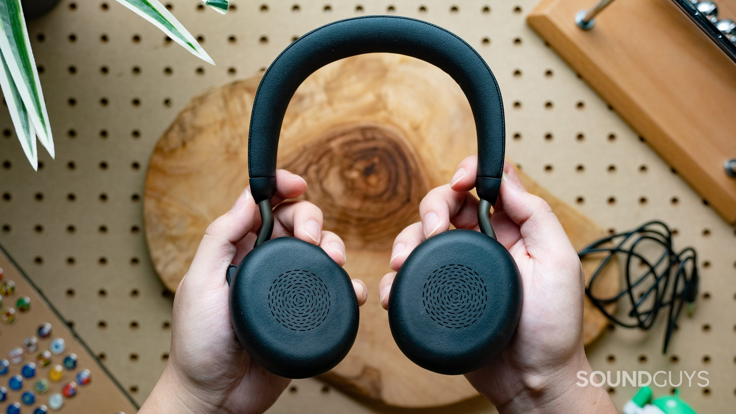 Jabra Evolve2 75 Featured Image #2 The Jabra Evolve2 75 headset being held firmly with two hands, with the pads of the earcups facing the viewer.