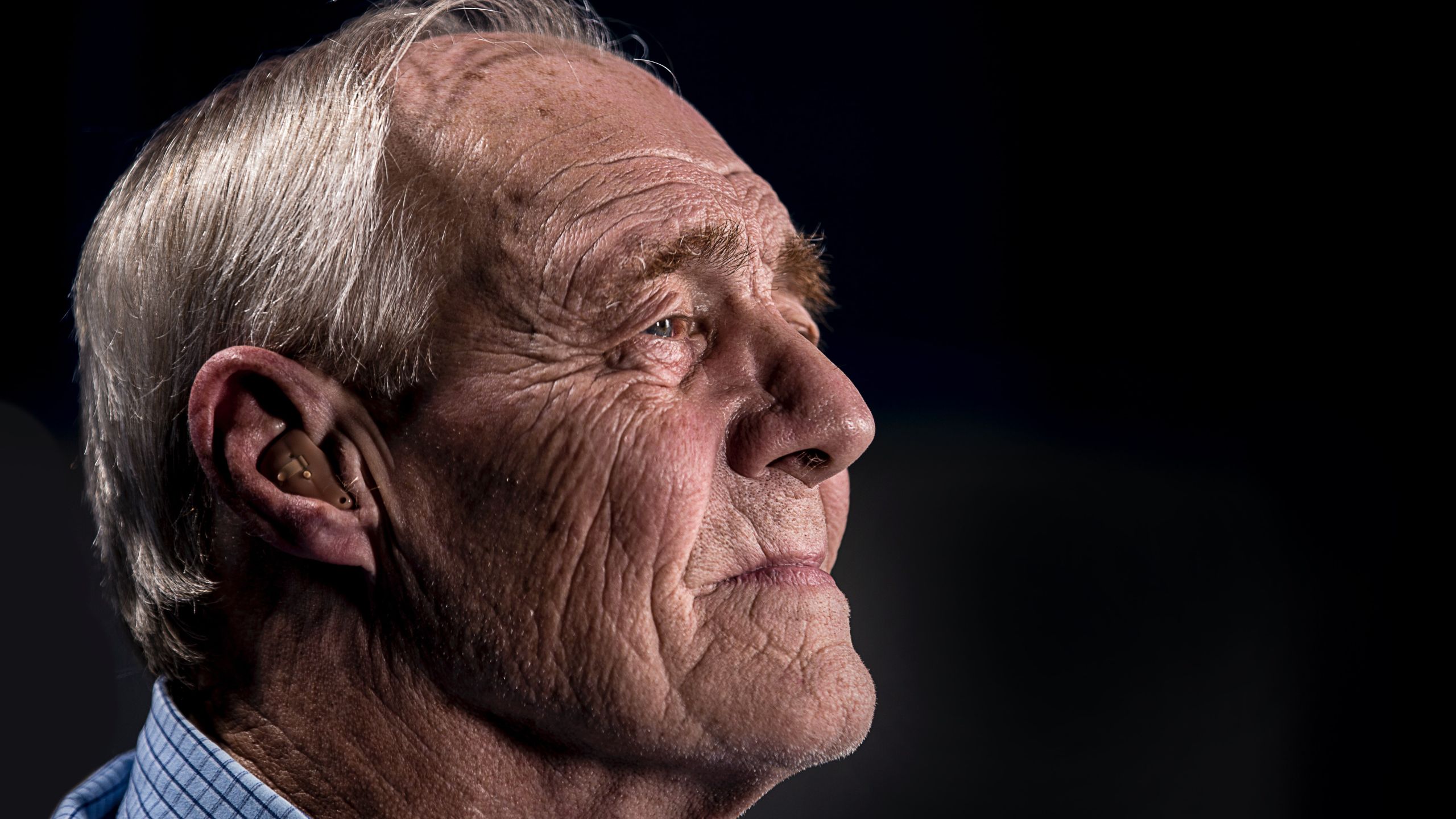 Man Wearing ITE Hearing Aid in Right Ear Elderly man with skin-colored ITE hearing aid.