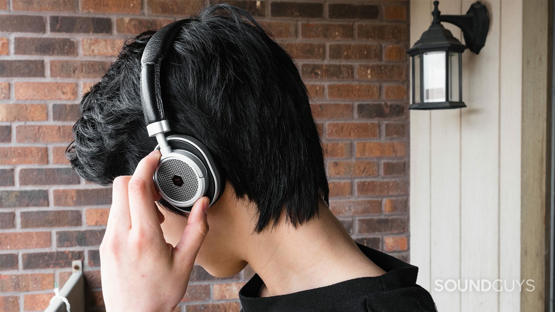 Master & Dynamic_M50 Wireless_LK_3 Master & Dynamic MW50 review: The headphones being worn while trying to use the small playback toggles.