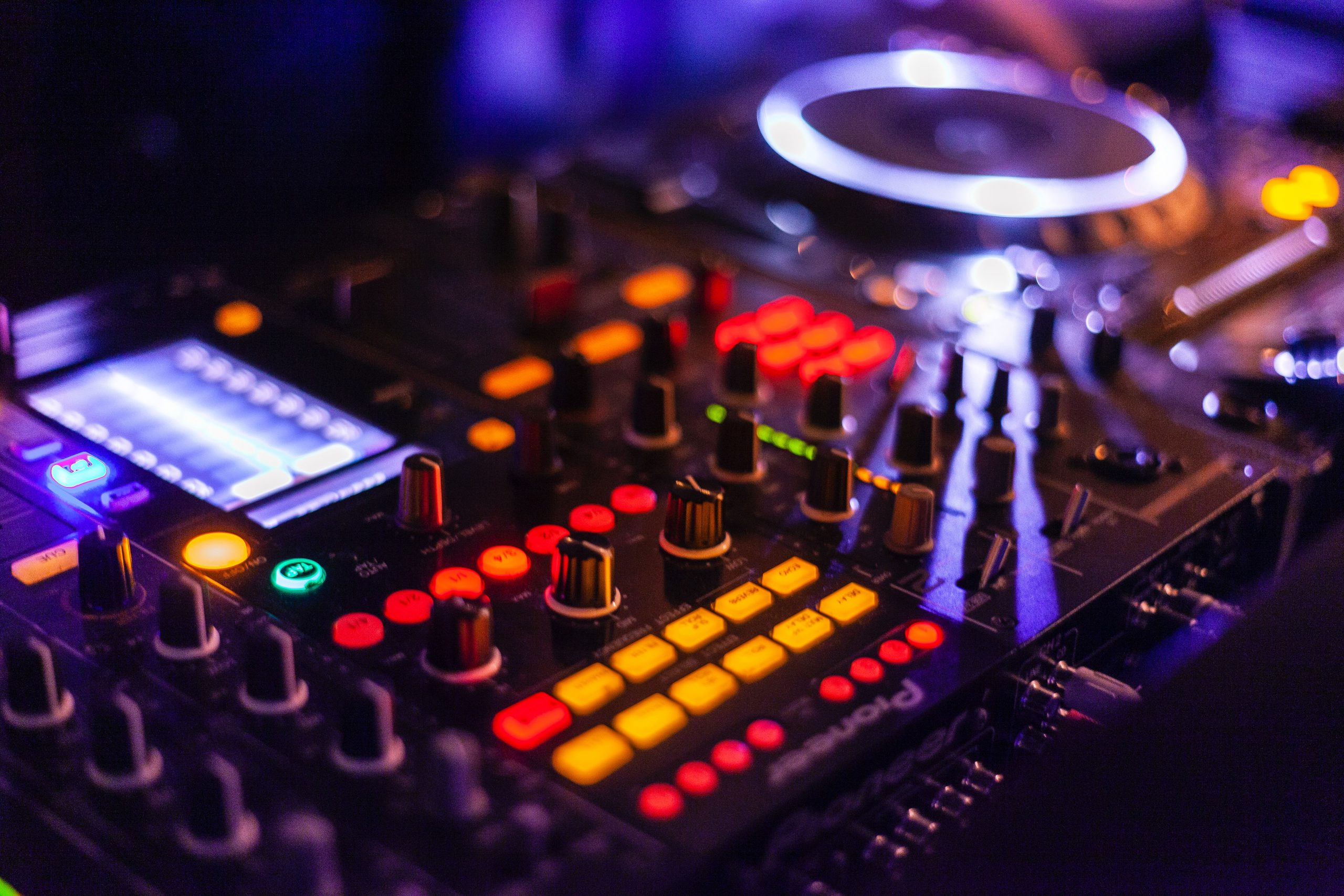 pexels-francesco-paggiaro-2111015 Audio mixer lit up in LEDs in a dark room.