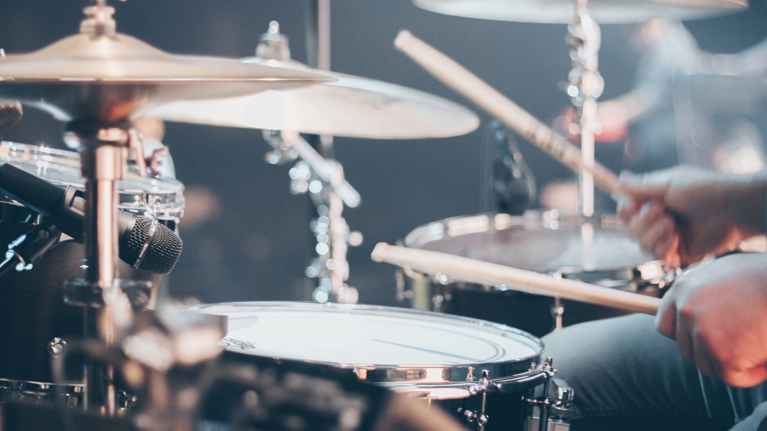 pexels-josh-sorenson-995301 A man plays a full drum kit.
