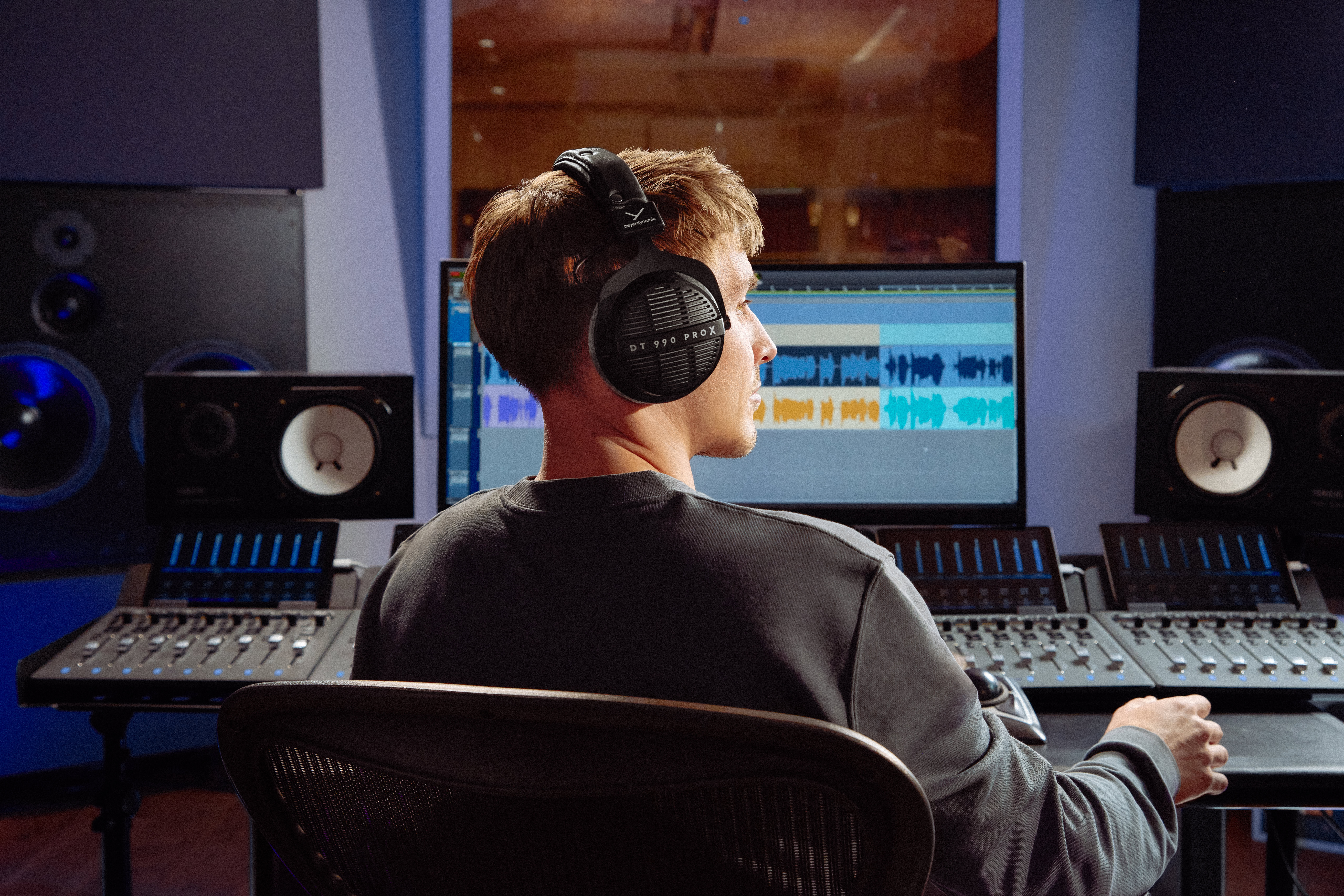 PIC_DT990PROX_25-05_Editing_v3 A man wearing the Beyerdynamic DT 990 PRO X headphones in a music studio.