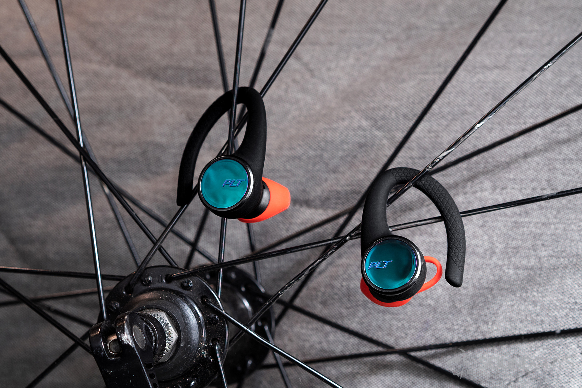 Plantronics_BackBeat Fit 3100-3 Plantronics BackBeat Fit 3100: The earbuds hanging from the spokes of a road bike wheel.