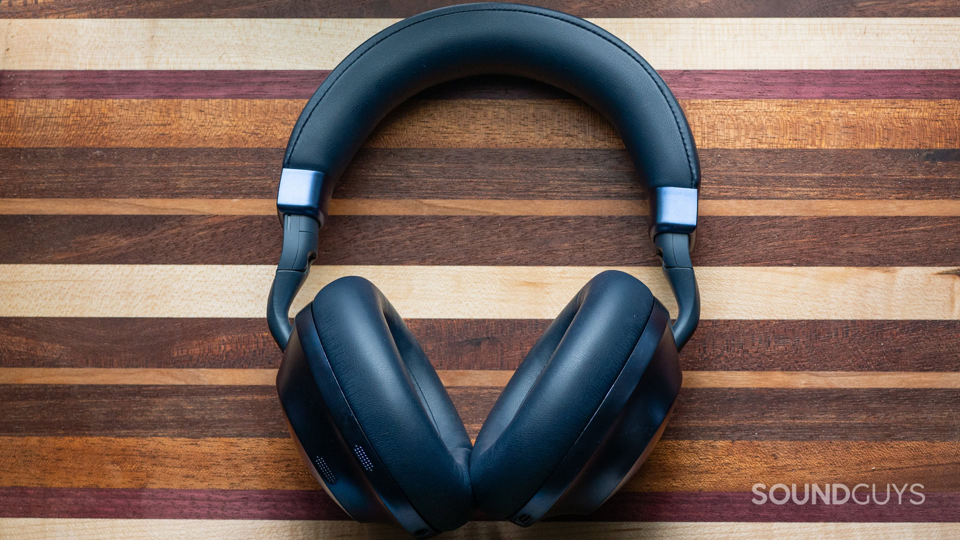 raycon-everyday-headphones-pro-hero A photo of the Raycon Everyday Headphones Pro sitting atop a wooden cutting board.
