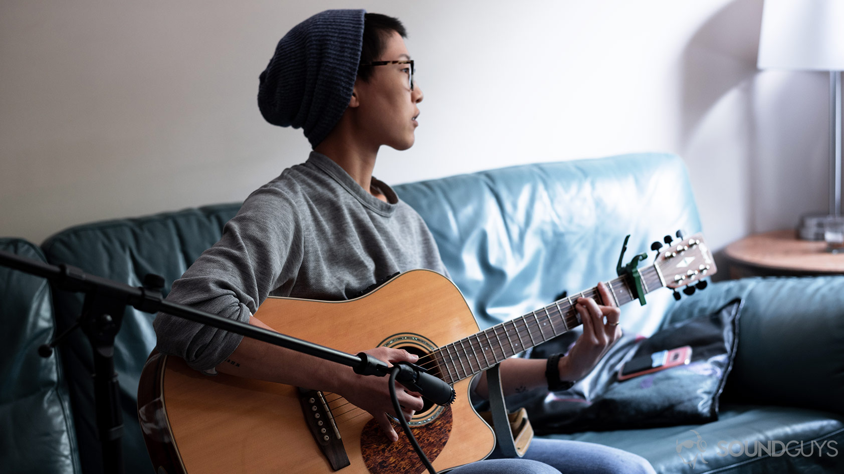 Shure SM57-3_microphone XLR woman guitar A picture of woman playing guitar and recording it with the Shure SM57 XLR mic.